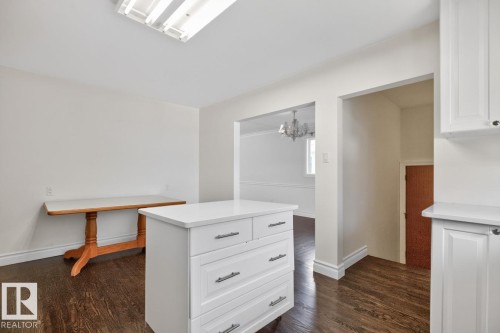 White cabinetry, wood-finish flooring, white walls, and a recessed ceiling light fixture - 7304 98A Avenue Nw, Edmonton, AB 