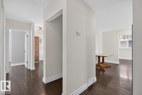 Dark wood-finish flooring throughout, complemented by white trim and neutral wall tones - 7304 98A Avenue Nw, Edmonton, AB 