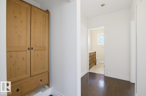 Dark wood-finish flooring, white baseboards, and bright white walls - 7304 98A Avenue Nw, Edmonton, AB 