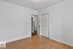 Wood-finish flooring, white walls, and a ceiling-mounted light fixture - 