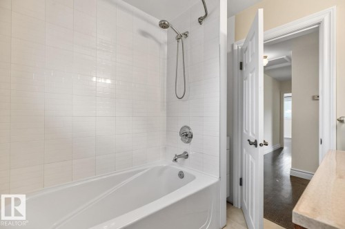 Bathtub with white tile surround and chrome fixtures - 7304 98A Avenue Nw, Edmonton, AB 