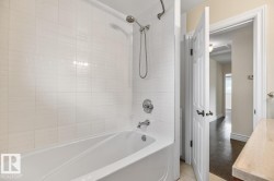 Bathtub with white tile surround and chrome fixtures - 