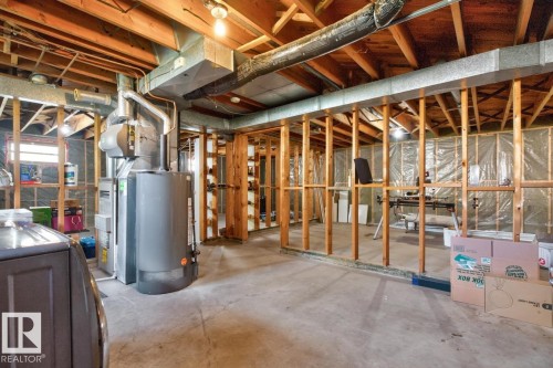Unfinished basement with exposed wood framing, concrete flooring, and visible ductwork - 7304 98A Avenue Nw, Edmonton, AB 