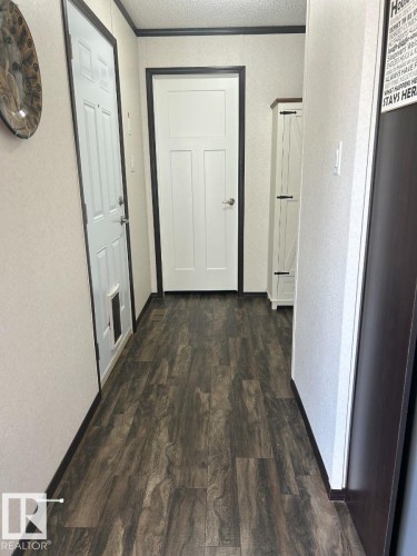 Wood-finish flooring throughout, complemented by white interior doors with dark trim - 63 Willow Park Estates, Leduc, AB 