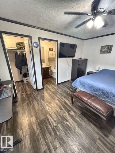 Wood-finish flooring throughout, ceiling fan with integrated lighting, and white walls with dark trim - 63 Willow Park Estates, Leduc, AB 