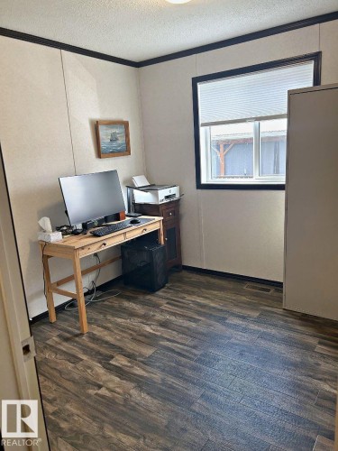Wood-finish flooring with a white wall paneling, featuring a window with blinds, and white trim - 63 Willow Park Estates, Leduc, AB 