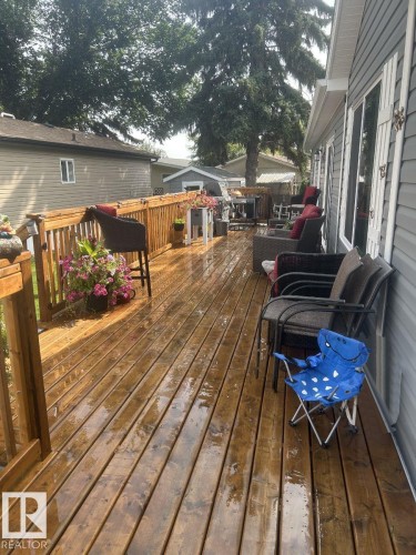 Expansive wood-finish deck with a wood railing system, offering generous outdoor living space - 63 Willow Park Estates, Leduc, AB 