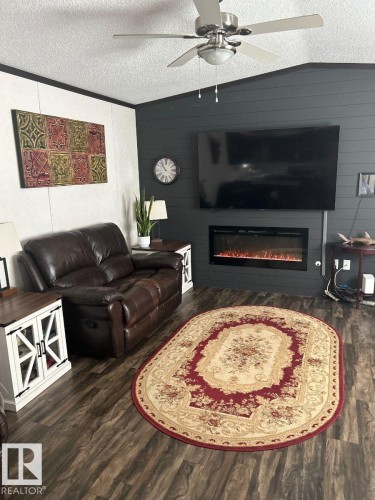Wood-finish flooring complemented by a ceiling fan with integrated lighting - 63 Willow Park Estates, Leduc, AB 