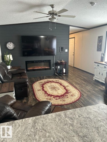 Shiplap accent wall featuring an electric fireplace - 63 Willow Park Estates, Leduc, AB 
