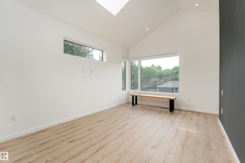 Vaulted ceiling featuring a skylight, recessed lighting, wood-finish flooring, and expansive windows - 10138 90 Street Nw, Edmonton, AB 