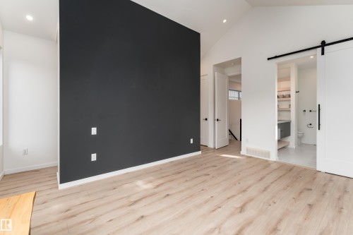 Vaulted ceiling, recessed lighting, wood-finish flooring, accent wall, and barn door entry - 10138 90 Street Nw, Edmonton, AB 