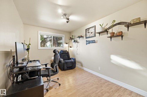 Neutral wall paint, wood-finish flooring, and a single window with white trim - 3523 106 Street Nw, Edmonton, AB 
