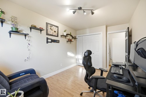 Recessed track lighting, light-toned wood-finish flooring, white bi-fold closet doors, and light-colored wall paint - 3523 106 Street Nw, Edmonton, AB 