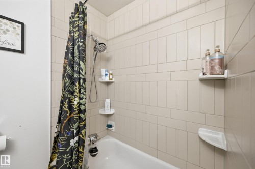 Bathtub with white subway tile surround and built-in corner shelves - 3523 106 Street Nw, Edmonton, AB 