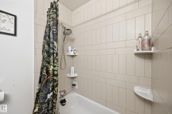 Bathtub with white subway tile surround and built-in corner shelves - 