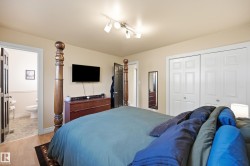 Wood-finish flooring, track lighting fixture, and white sliding closet doors - 