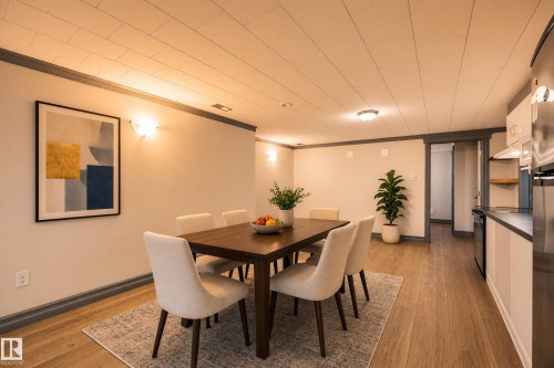 Integrated dining area featuring wood-finish flooring, recessed lighting, and wall sconces - 3523 106 Street Nw, Edmonton, AB 