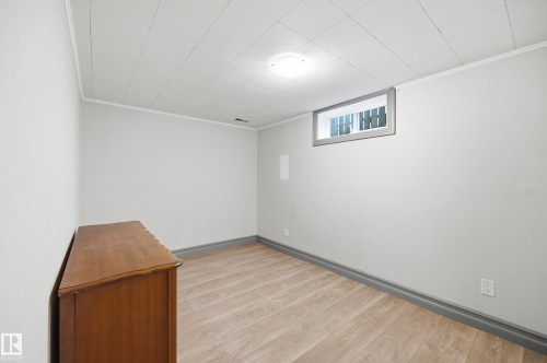 Light-toned wood-finish flooring, white painted walls, and a drop ceiling with recessed lighting - 3523 106 Street Nw, Edmonton, AB 