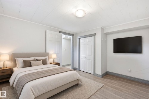 Wood-finish flooring, white walls, and a bi-fold closet door - 3523 106 Street Nw, Edmonton, AB 