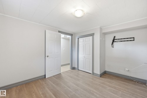 Wood-finish flooring with coordinating baseboards - 3523 106 Street Nw, Edmonton, AB 