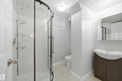 Curved glass shower enclosure with white subway tile surround - 