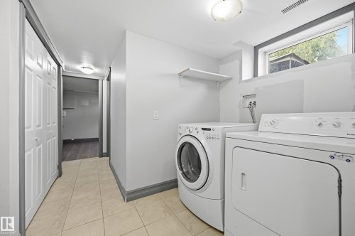 Laundry area featuring a window, overhead lighting, and a wall-mounted shelf - 3523 106 Street Nw, Edmonton, AB 