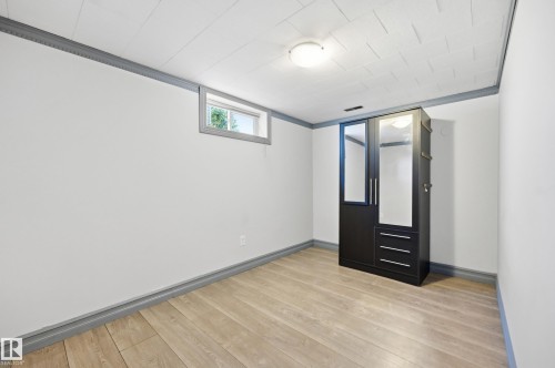 Wood-finish flooring, white walls, and a window providing natural light - 3523 106 Street Nw, Edmonton, AB 