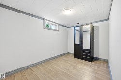 Wood-finish flooring, white walls, and a window providing natural light - 
