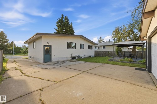 Stucco exterior, fenced yard, concrete driveway, detached garage, and a raised wooden deck with a gazebo - 3523 106 Street Nw, Edmonton, AB 