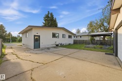 Stucco exterior, fenced yard, concrete driveway, detached garage, and a raised wooden deck with a gazebo - 