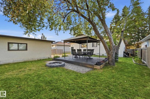 Expansive backyard featuring a stone-paver patio, wood-finish deck with a gazebo, and a built-in fire pit - 3523 106 Street Nw, Edmonton, AB 