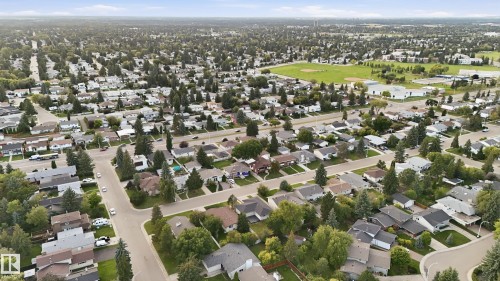 Expansive residential area with numerous detached properties, abundant mature trees, and a visible recreational field - 3523 106 Street Nw, Edmonton, AB 