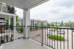 Balcony featuring a textured concrete surface and black metal railings - 