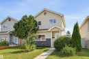 Two-story exterior with light-colored siding, contrasting dark stone-clad lower facade, and a covered entry - 4125 38 Street Nw, Edmonton, AB 