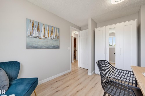 Wood-finish flooring, white trim, and a white built-in wardrobe with mirrored panel - 4125 38 Street Nw, Edmonton, AB 