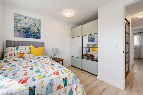 Wood-finish flooring, built-in mirrored wardrobe, paneled interior door, flush-mount ceiling light - 4125 38 Street Nw, Edmonton, AB 