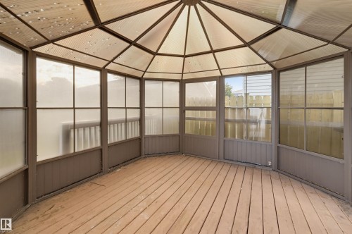 Gazebo structure with a multi-paneled translucent roof, frosted panel walls, wood-finish flooring, and a panel door - 4125 38 Street Nw, Edmonton, AB 