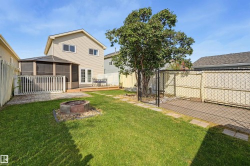 Expansive grassy yard featuring a built-in fire pit, a multi-level deck, and a screened gazebo structure - 4125 38 Street Nw, Edmonton, AB 