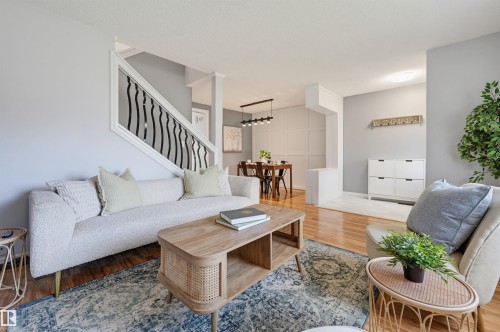 Hardwood-finish flooring, staircase with decorative wrought iron spindles, recessed lighting, dining area with modern linear chandelier, and wall paneling - 4125 38 Street Nw, Edmonton, AB 