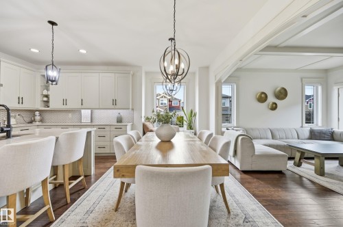 Open-concept living space with dark wood-finish flooring, white coffered ceiling, and pendant light fixtures - 1961 Adamson Terrace Sw, Edmonton, AB 