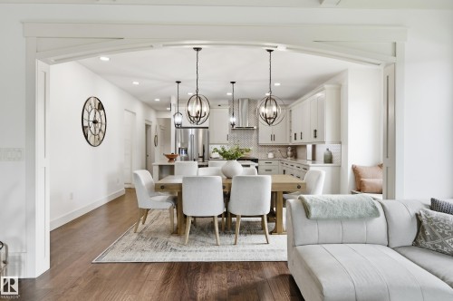 Open concept dining area with dark wood-finish flooring, recessed lighting, and decorative archway - 1961 Adamson Terrace Sw, Edmonton, AB 
