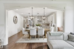 Open concept dining area with dark wood-finish flooring, recessed lighting, and decorative archway - 