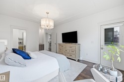 Hardwood-finish flooring, white walls, decorative ceiling light fixture, recessed ceiling detail, and a white exterior door with glass insert - 