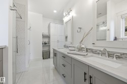 Dual vanity with undermount sinks, stone countertops, and tile backsplash - 
