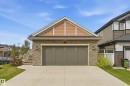 Stone-clad exterior featuring a two-car garage with a concrete driveway - 1961 Adamson Terrace Sw, Edmonton, AB 