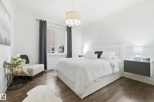 Wood-finish flooring, white walls with crown molding, window with blinds, and a built-in floating nightstand - 1961 Adamson Terrace Sw, Edmonton, AB 