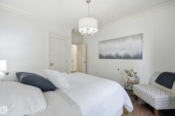 White walls with crown molding, wood-finish flooring, and a contemporary drum chandelier - 