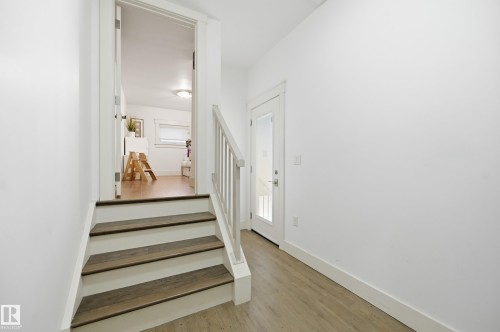 Open doorway, hardwood flooring, white walls, white trim, staircase with wood-finish treads - 1961 Adamson Terrace Sw, Edmonton, AB 