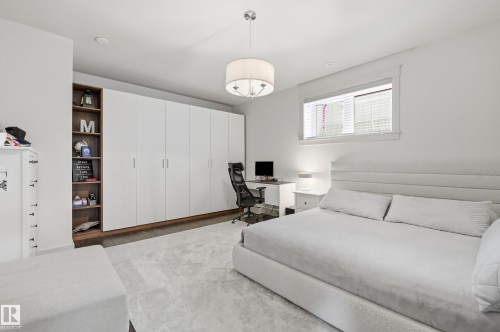 Built-in white cabinetry with wood-finish shelving, recessed lighting, and a drum pendant light fixture - 1961 Adamson Terrace Sw, Edmonton, AB 