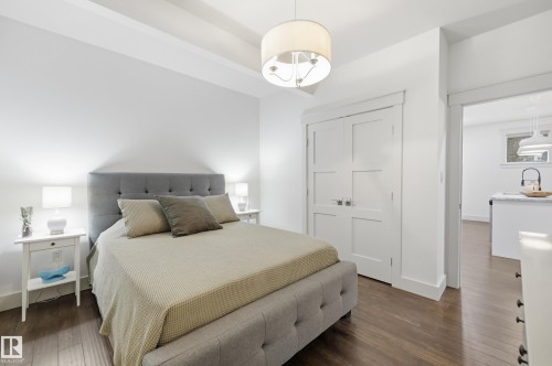 Hardwood-style flooring throughout, white walls, flush-panel bi-fold closet doors, and recessed ceiling beams - 1961 Adamson Terrace Sw, Edmonton, AB 